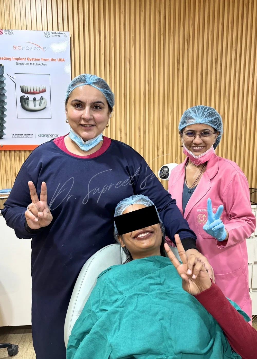 Patient seated with Dr. Supreet Sawhney and a clinical team member after treatment